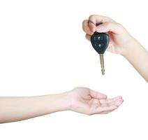 A hand giving a car keys to another hand photo