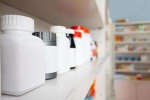 medicine bottles arranged on shelf at drugstore photo