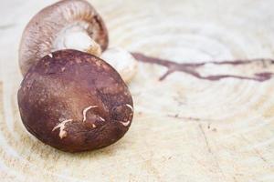 hongos shiitake en una tabla de cortar de madera foto