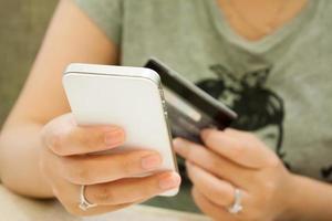 female holding smartphone and credit card, shopping online concept photo