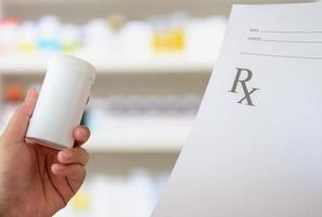 female pharmacist with prescription and medicine bottle at the pharmacy photo