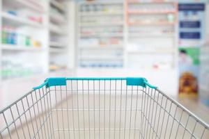 blur shelves of drugs in the pharmacy with shopping cart photo