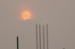 The red sun at dawn was fog over the tip of the rebar in the construction site.