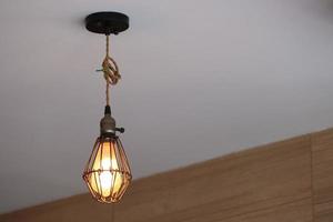 lámpara de metal antigua en el techo, la bombilla está encendida. bombillas colgando del techo con fondo blanco, bombillas de alambre viejas.
