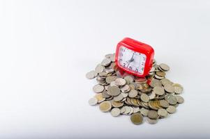 Money, baht coins on a white background and a red clock photo