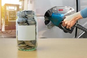 Money bottle with coins, Hand holding Fuel nozzle pouring background photo