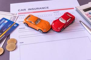 Car insurance form with model and policy document photo