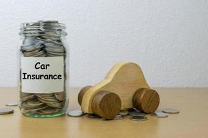 ahorro de dinero para el seguro de automóvil en la botella de vidrio foto