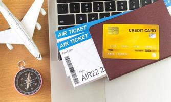boletos aéreos y pasaportes cerca de la computadora portátil y el avión en la mesa. concepto de reserva de boletos en línea foto