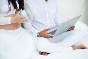 Pregnant couples searching for information on laptops for their newborn care New parents