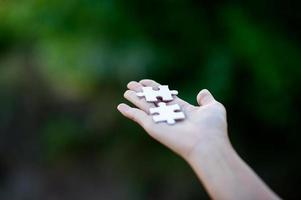 Hands and white jigsaw puzzles Close-up image and integration Business concept and unity photo