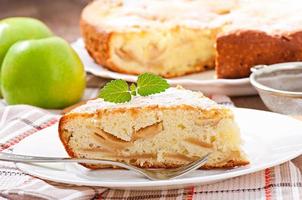 Slice of apple fruit pie on a plate decorated with mint leaf photo