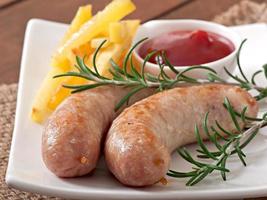 Chicken sausages grilled with a side dish of  french fries photo