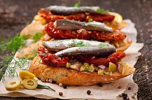 Crostini with anchovies, olives and sun-dried tomatoes photo