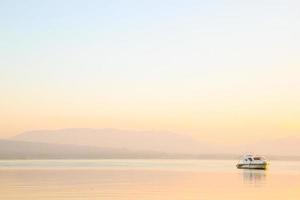 barco del lago en el fondo naranja de la puesta de sol en el lago toba foto