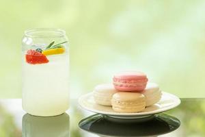 delicious juicy fresh lemon soda on glass table Blurred leaf reflection background photo