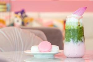 Close up of delicious juicy fresh milk green tea  on glass table Blurred leaf reflection background photo