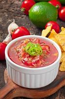 Mexican nacho chips and salsa dip in  bowl on  wooden background photo