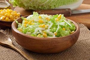 Chinese cabbage salad with sweet corn in a wooden bowl photo