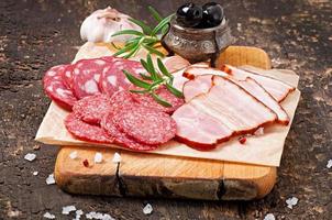 Assorted deli meats, rosemary and pepper photo