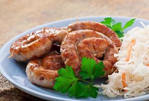 Bavarian fried sausages on sauerkraut photo