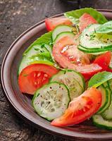 Tomato and cucumber salad with black pepper and basil photo