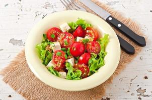 Tomato salad with lettuce, cheese and mustard and garlic dressing photo