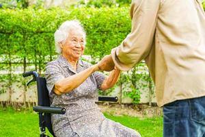 anciana asiática discapacitada paciente sentada en silla de ruedas en el parque, concepto médico. foto