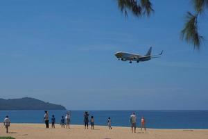 phuket, tailandia, 2020 - turistas esperando para tomar fotos con aviones en la playa de mai khao.