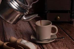 metal carafe pouring hot coffee in a cup photo