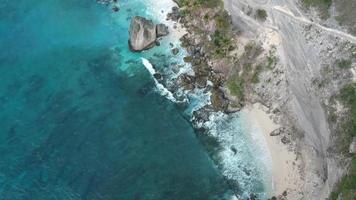 Aerial drone view of atuh beach and blue ocean waves In Nusa Penida, Bali, Indonesia. Overhead View Of Rocky Coast And Coves video