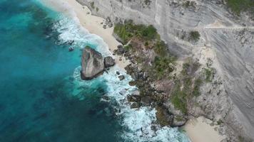 flyg drönarevy över atuh beach och blå havsvågor i nusa penida, bali, Indonesien. översikt över klippiga kusten och vikar video