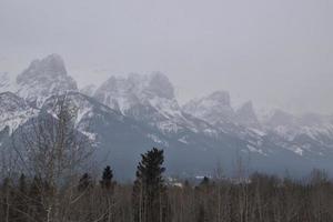 Snow Covered Rocky Mountains with Hazy Grey Sky photo