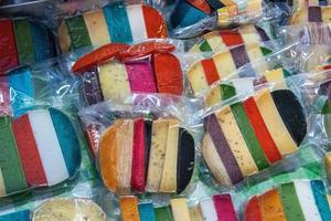 Brightly coloured favored cheese wrapped for sale at a market. photo