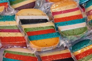 Brightly coloured favored cheese wrapped for sale at a market. photo
