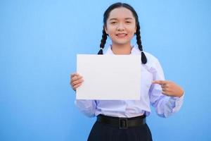 niña de la escuela con cartelera sobre fondo azul. foto