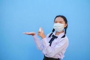 School girl wear mask on blue background,Back to school. photo