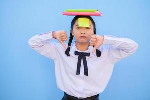 Student with book and small note paper on blue background. photo