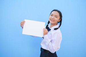 niña de la escuela con cartelera sobre fondo azul. foto