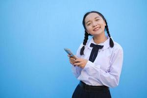 Student young girl useing smart phone on blue background. photo