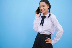 Student young girl useing smart phone on blue background. photo