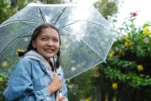 Smile young girl having fun in rainy. photo