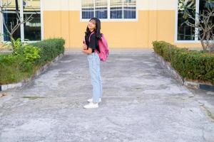 niña feliz de pie en la escuela. foto