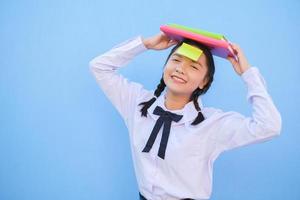 Student with book and small note paper on blue background. photo