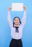 School girl holding billboard on blue background. photo