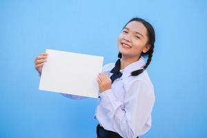 School girl holding billboard on blue background. photo