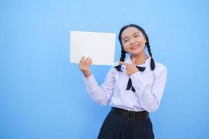 School girl holding billboard on blue background. photo