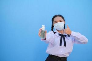 School girl wear mask on blue background,Back to school. photo