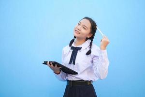 School girl holding tablet on blue background. photo