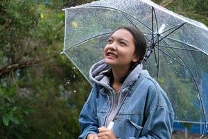 sonrisa joven divirtiéndose en la lluvia. foto